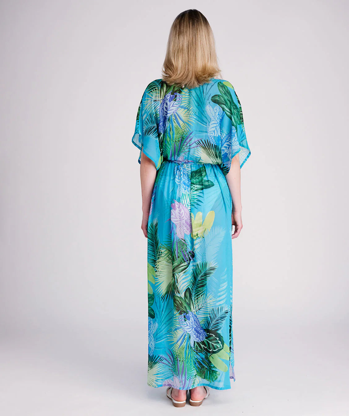 Woman in a colorful dress standing on a wooden pier.