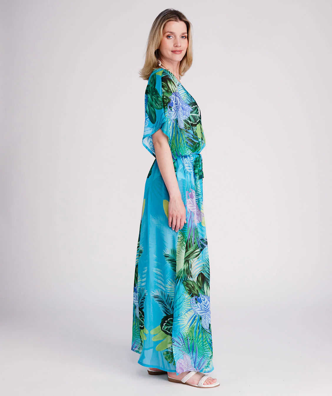 Woman in a colorful dress standing on a wooden pier.