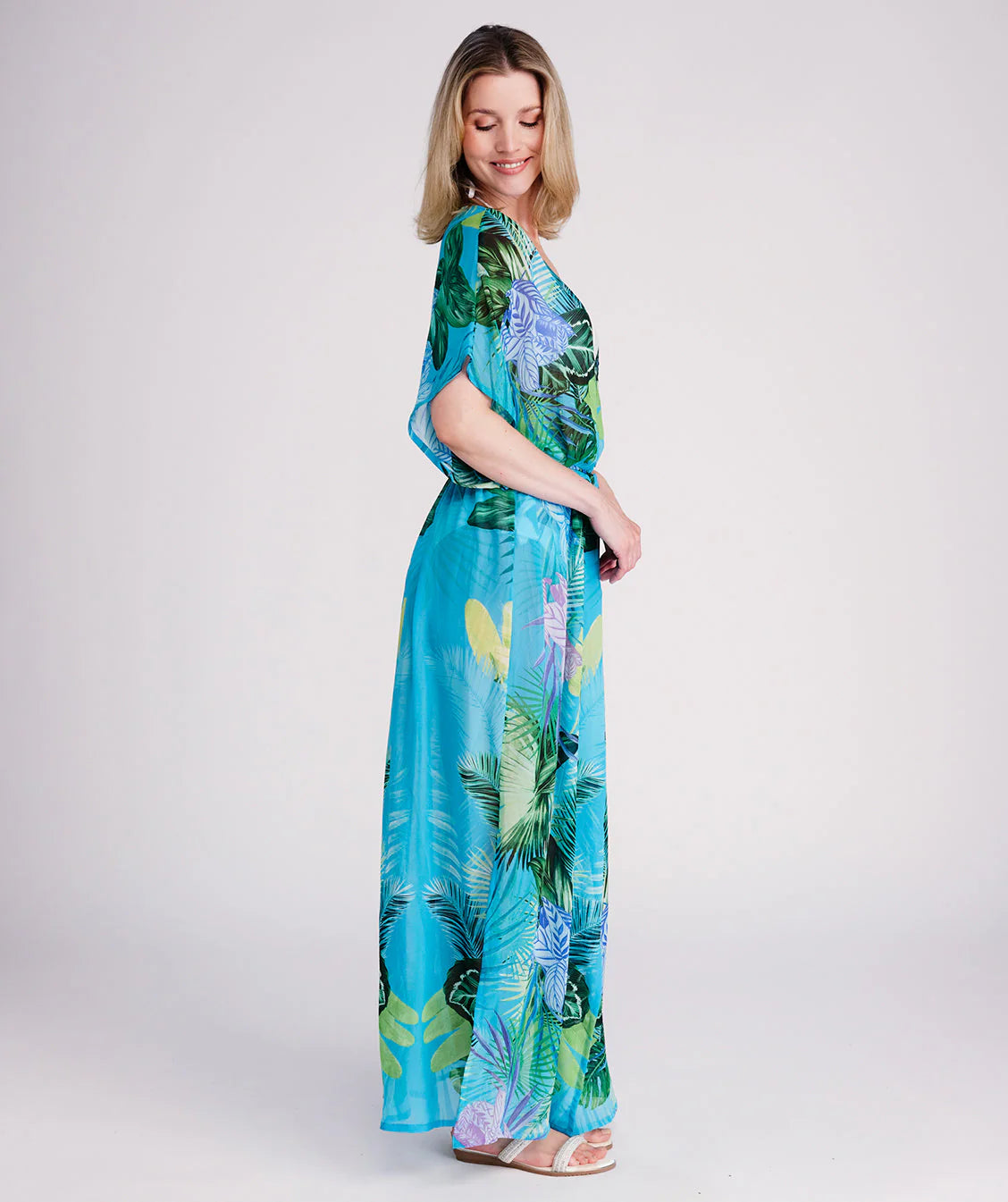 Woman in a colorful dress standing on a wooden pier.