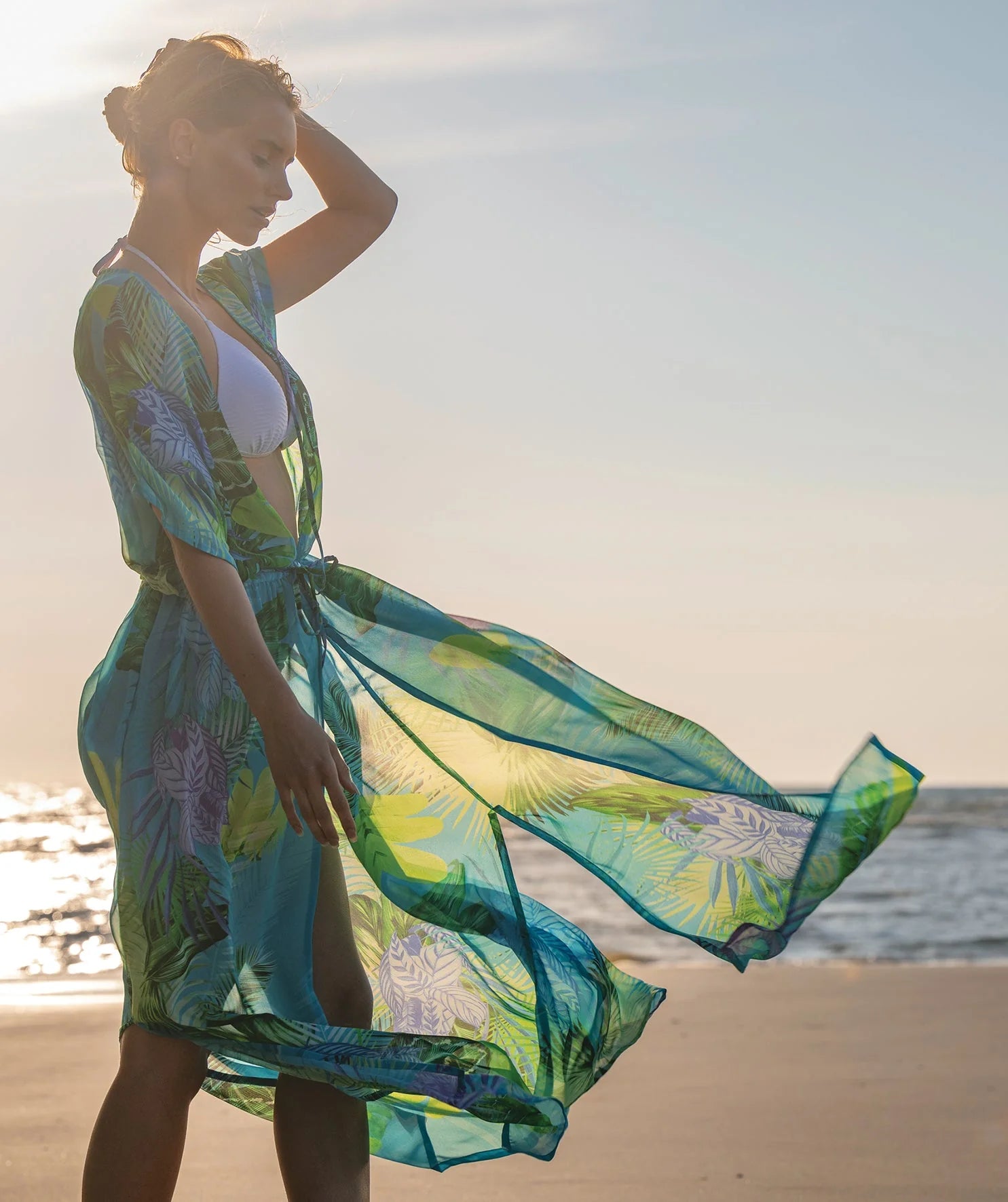 Woman in a colorful dress standing on a wooden pier.