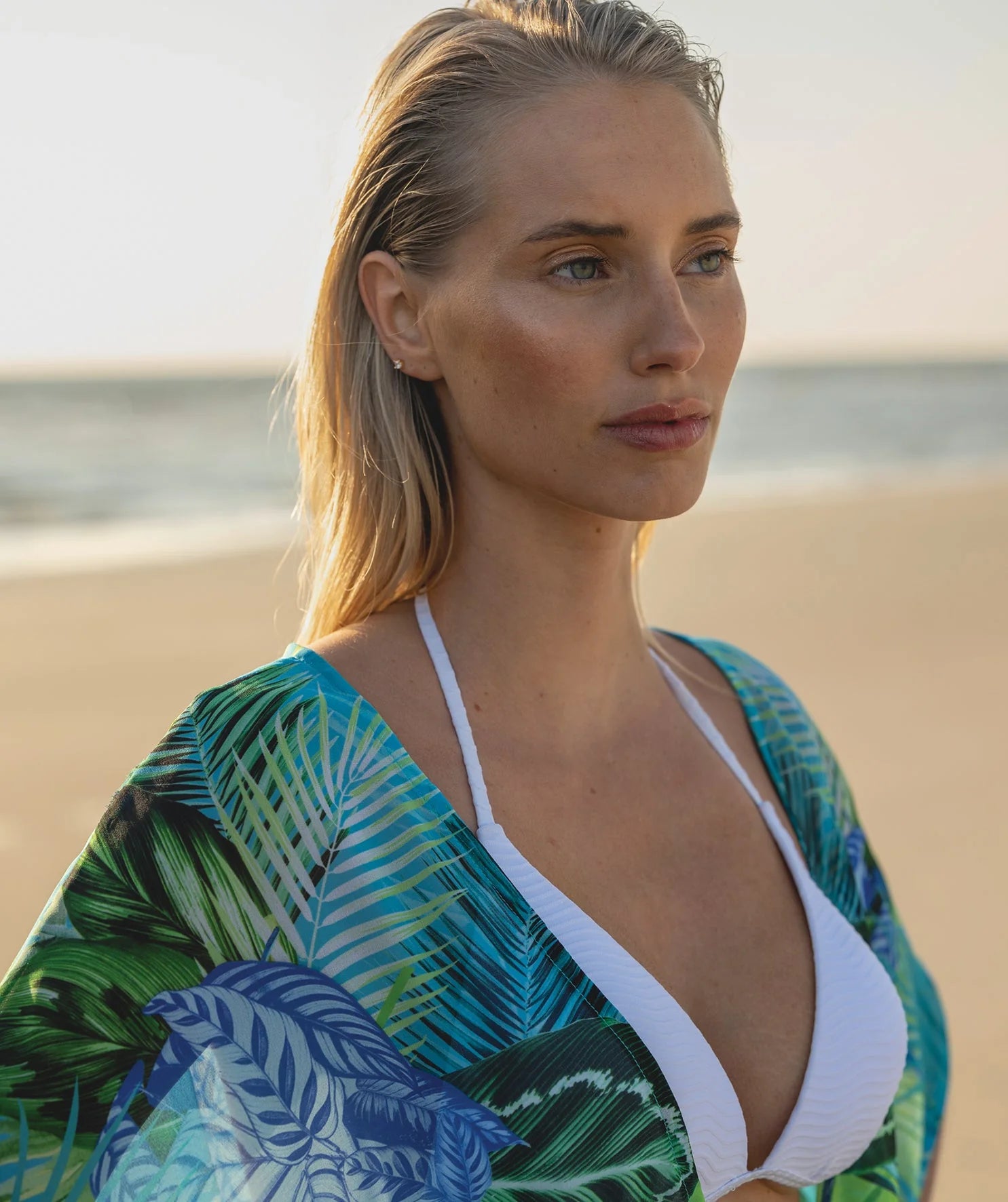 Woman in a colorful dress standing on a wooden pier.