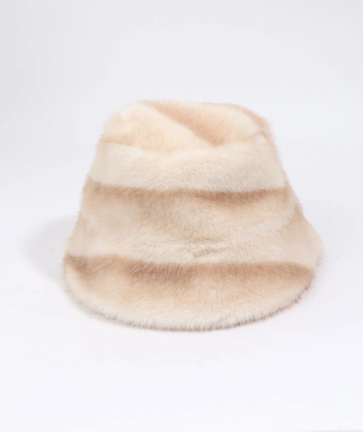 A fuzzy faux fur bucket hat in a soft beige and cream color-blocked pattern
